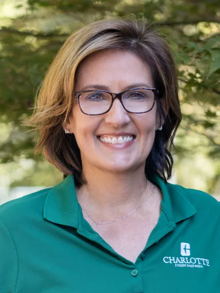 Profile photo of Laurie Cuddy smiling, wearing a green polo shirt with the UNC Charlotte logo